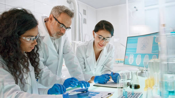 istock Research laboratory interior with medical samples. Multi ethnic team comparing test results 1275317525