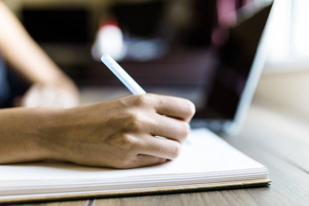 istock Young woman working on laptop and taking a note 1275326695