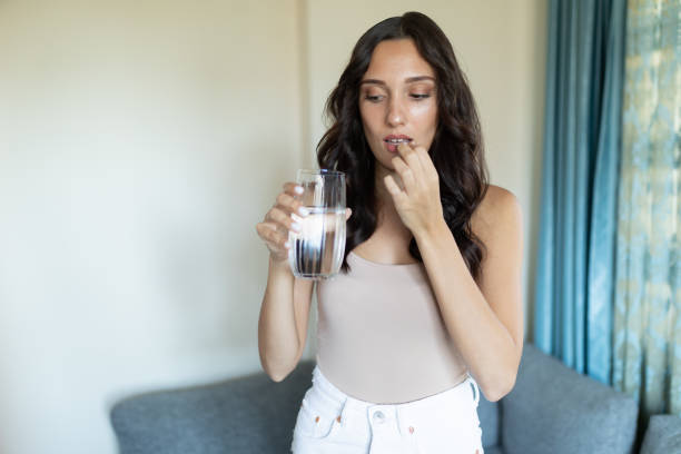 istock Young women taking a pill 1275326933