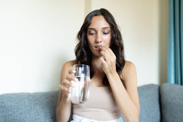 istock Young women taking a pill 1275326960