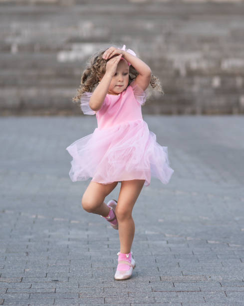 gadis kecil berpakaian merah muda berputar di jalan - raja spin potret stok, foto, & gambar bebas royalti