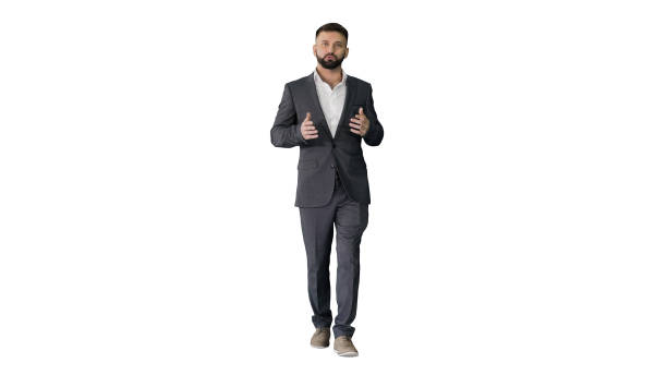 Bearded turk businessman walking and talking to camera on white Wide shot. Front view. Bearded turk businessman walking and talking to camera on white background. Professional shot in 4K resolution. 044. You can use it e.g. in your medical, commercial video, business, presentation, broadcast presenter stock pictures, royalty-free photos & images