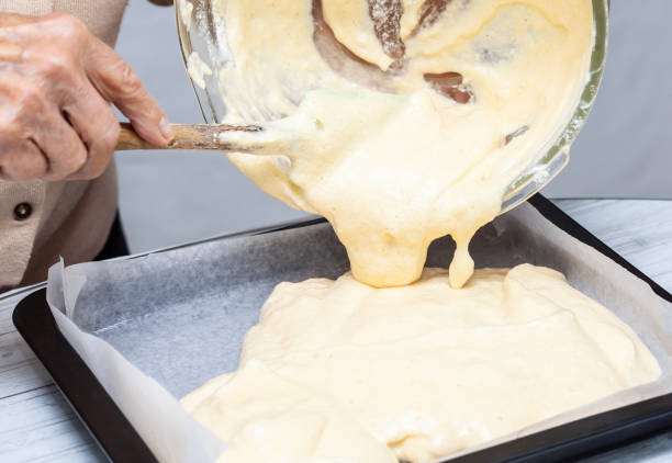 istock Close up of sponge cake dough being poured into a baking tin 1275344965