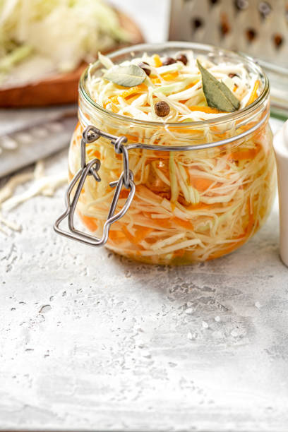 istock Shredded cabbage and carrots in a glass jar on the table close-up. 1275345070