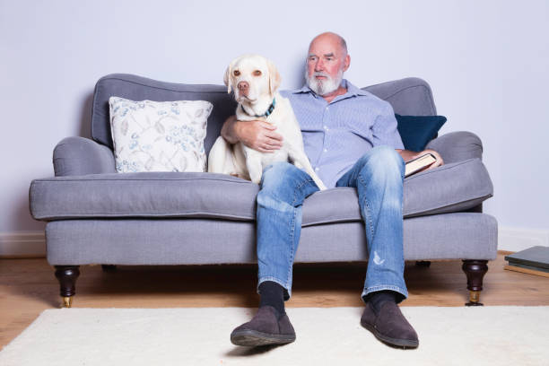 istock Senior man on the sofa with his dog 1275372482