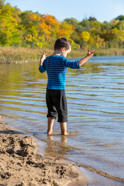 istock Boy Playing In Water at Beach on Autumn Day 1275377197