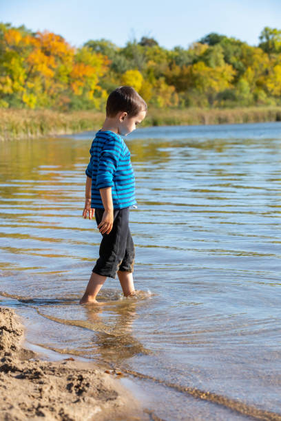 istock Boy Playing In Water at Beach on Autumn Day 1275378447