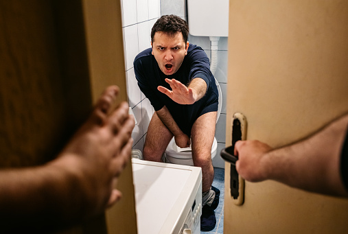 Young man in toilet disturbed by someone got angry and start shouting.