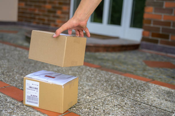 istock Delivery man delivering parcel at doorstep 1275401608