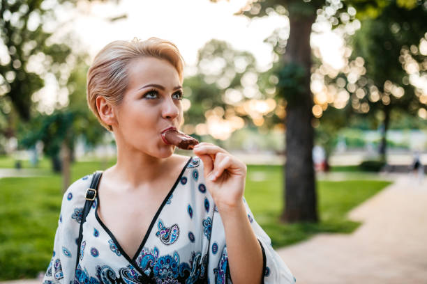 istock Woman eating ice-cream in park 1275405430
