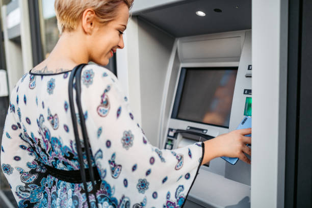 istock Withdrawing money at the ATM with phone 1275407945