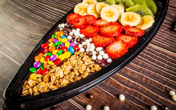 Acai frozen with banana, kiwi fruit, granola and candies for share. A boat for share. Acai frozen with banana, kiwi fruit, granola and candies for share. A boat for share. superfruit stock pictures, royalty-free photos & images