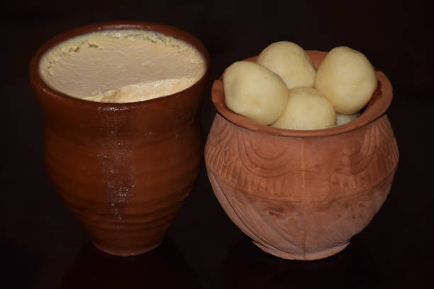 Traditional Indian Bengali Sweet Misti Doi (sweet Curd) with Rosogolla served in earthen pots Traditional Indian Bengali Sweet Misti Doi (sweet Curd) with Rosogolla served in earthen pots rosogolla stock pictures, royalty-free photos & images