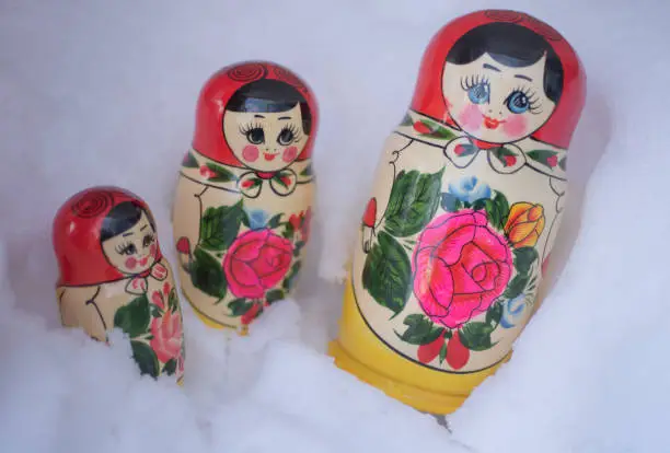 Photo of Traditional russian wooden nesting dolls Matryoshka arranged in the real glittering snow.