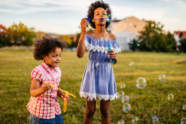 istock Happy girls having fun with soap bubbles in the nature 1275416995