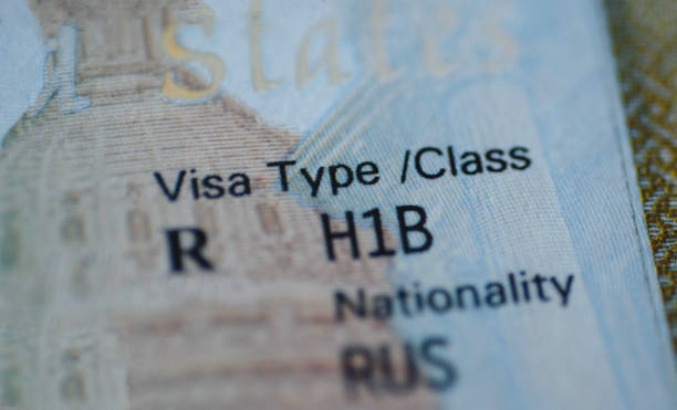 kuvapankkikuvat ja rojaltivapaat kuvat aiheesta pala h1b-viisumia (erikoistyöntekijöille) leima passissa, epäselvä huhtikuun kalenteri taustalla. h1b-viisumiohjelman määräaikakonsepti. lähikuva. - maahanmuutto
