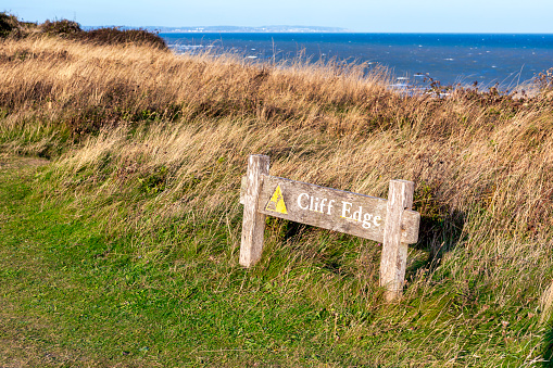 Warning sign at the edge of Eastbourne Cliffs, East Sussex, England.