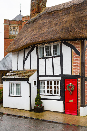 WINSLOW, UK - December 26, 2019. Facade of an English thatched cottage house at Christmas, winter. Street scene in Buckinghamshire UK