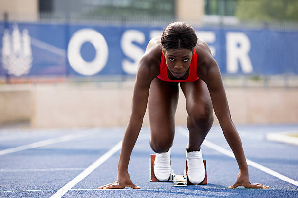 corridore in blocchi di partenza sulla pista - atleta di atletica leggera foto e immagini stock