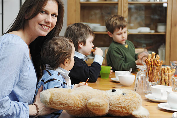 mãe sentada com filhos à mesa - fey imagens e fotografias de stock