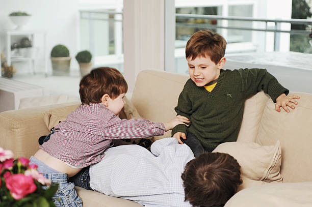 niños jugando en el sofá - jugar a luchar fotografías e imágenes de stock