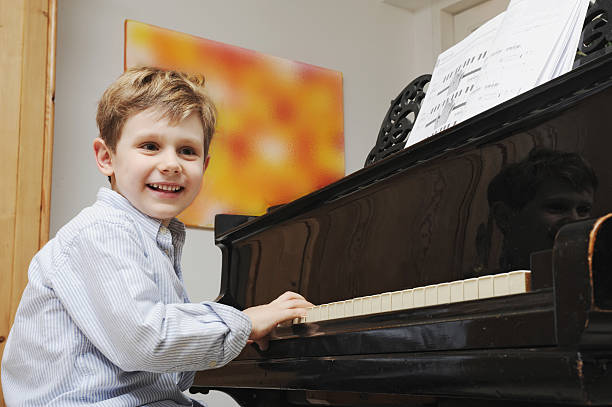 ragazzo suona il pianoforte nel soggiorno - fey foto e immagini stock