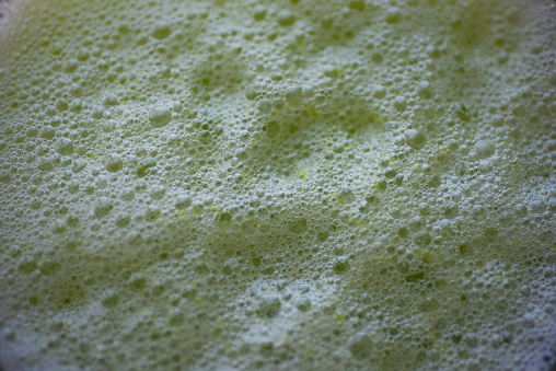 Green smoothie foam background, close up view.
