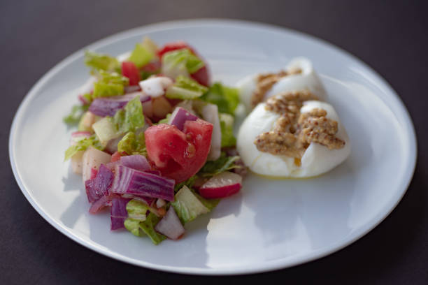 Salad with chinese cabbage, onion, sausage, eggs and mayonnaise on wooden table