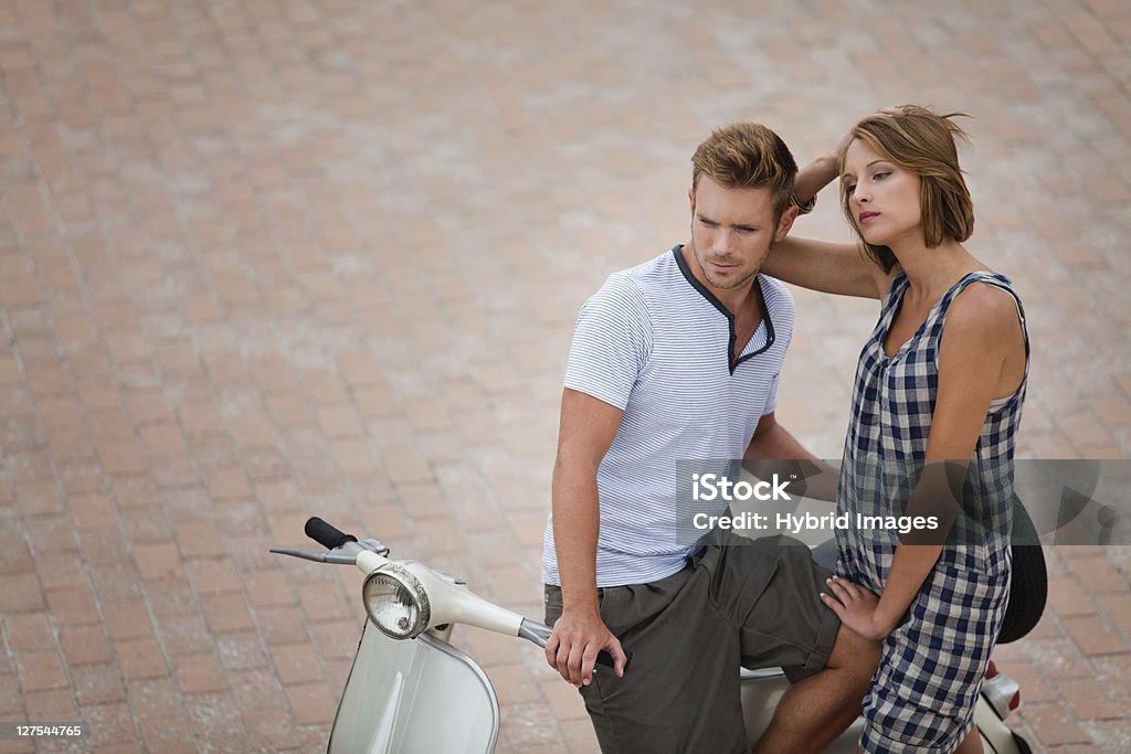 Couple sitting on scooter together  18-19 Years Stock Photo