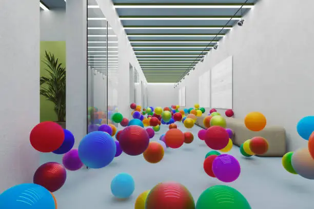 Photo of Bouncing colorful spheres in empty office