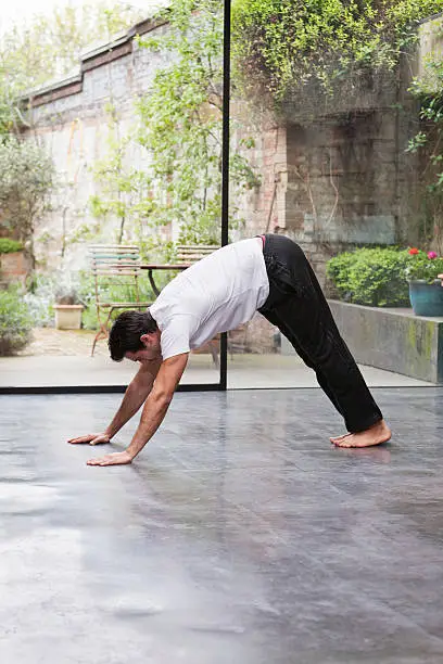 Photo of Man practicing downward dog yoga pose