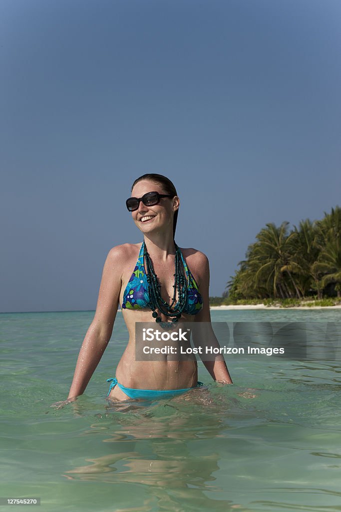 Woman standing in water on beach  25-29 Years Stock Photo