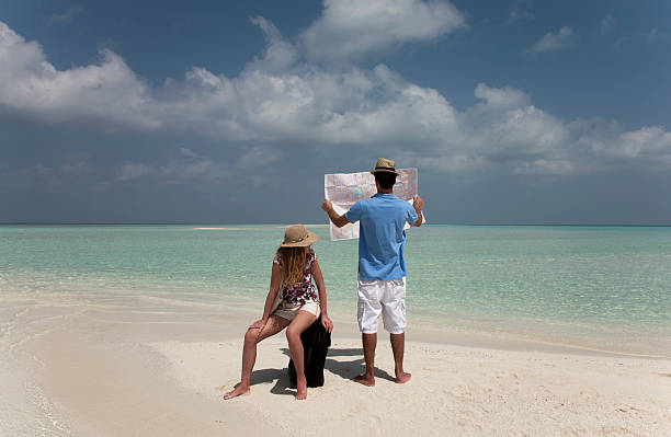 mapa de lectura de pareja en la playa tropical - lost beach fotografías e imágenes de stock