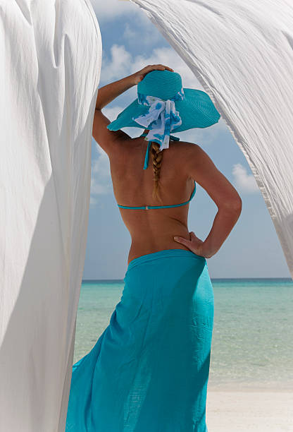 женщина на пляже за белые шторы - women sarong beach white стоковые фото и изображения