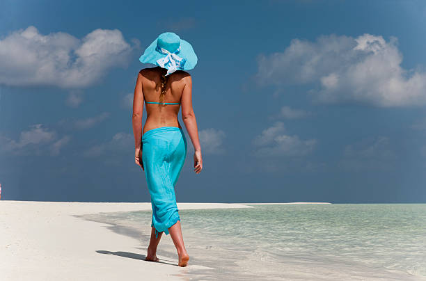 Woman walking on tropical beach  sarong stock pictures, royalty-free photos & images