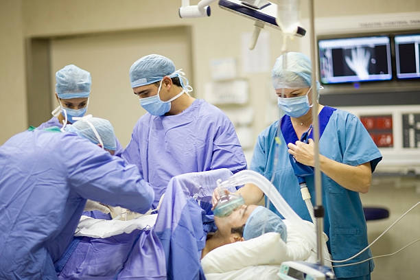 Doctor and nurses performing operation  operating room photos stock pictures, royalty-free photos & images