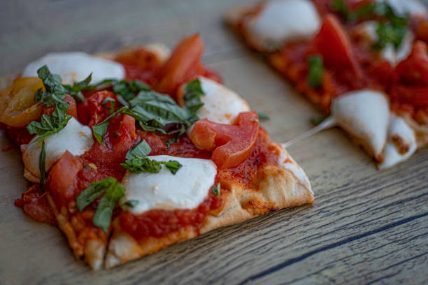 Three pieces of Classic Margherita Flatbread Pizza on wooden board stock photo