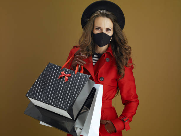 istock elegant female in red coat on brown background 1275464765