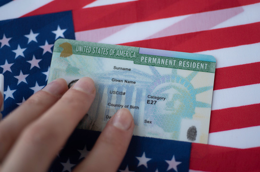 Tarjeta verde residente permanente de los Estados Unidos de América en la bandera de EE.UU. Vista de cerca. photo