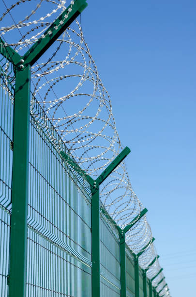 istock Tall metal fence with barbed wire. 1275465296