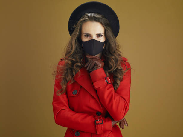 istock pensive stylish female in red coat against brown background 1275465302