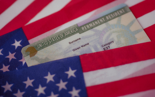 Permanent Resident Green card  of United states covered of flag of USA.