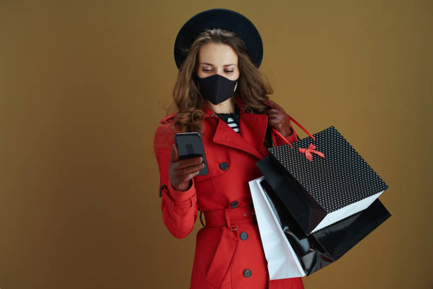 istock woman using smartphone applications against bronze background 1275465336