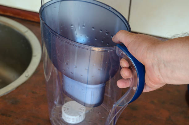 istock An empty water jug in hand next to the sink. 1275465364