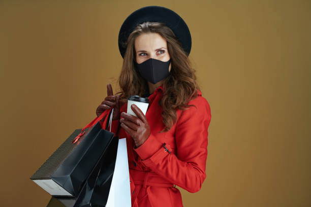 istock pensive young female in red coat isolated on brown background 1275465397