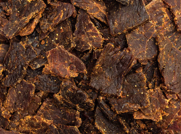 carne seca. feche. fundo alimentar. - beef jerky meat smoked - fotografias e filmes do acervo