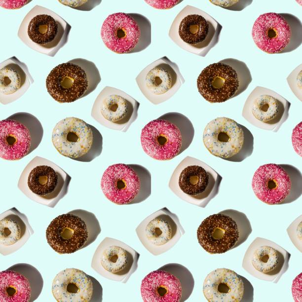 istock Beautiful colorful pattern of pink, white and chocolate donuts on white background. 1275472851