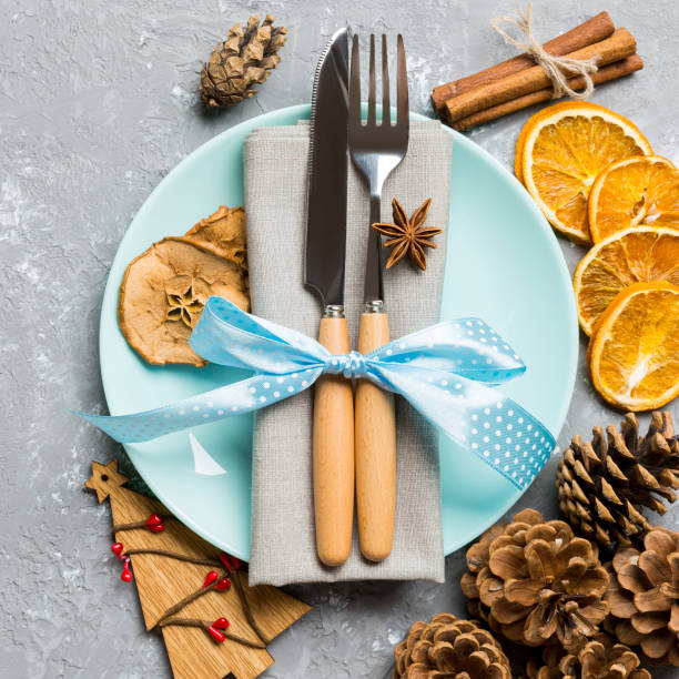 istock Top view of holiday dinner decorated with dried fruit and cinnamon on cement background. Set of plate, urensil and New Year decorations. Christmas time concept with epmty space for your design 1275493353