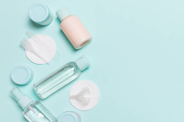istock Group of small bottles for travelling on blue background. Copy space for your ideas. Flat lay composition of cosmetic products. Top view of cream containers with cotton pads 1275494020