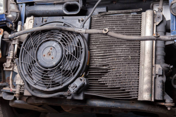 a very old and damaged radiator in a car is replaced by a mechanic - condenser imagens e fotografias de stock